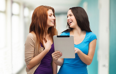 two smiling teenagers with tablet pc computer