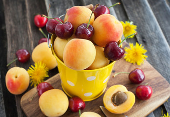 Fresh apricot and cherry in a bucket