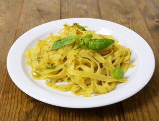 Delicious pasta with pesto on plate on table close-up
