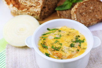 Tasty soup in saucepan on tablecloth, close up