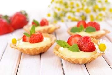 Tasty tartlets with strawberries on table close-up