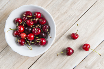 Cerezas frescas en un cuenco de china blanco sobre la mesa