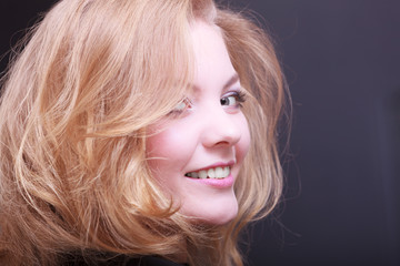 Girl with blond wavy hair by hairdresser in beauty salon