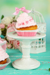 Tasty cup cakes with cream on blue wooden table