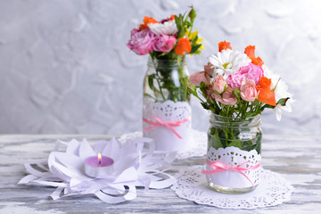 Beautiful bouquet of bright flowers in jars