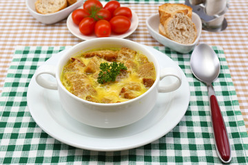 Tasty soup in saucepan on tablecloth, close up