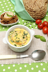 Tasty soup in saucepan on tablecloth, close up