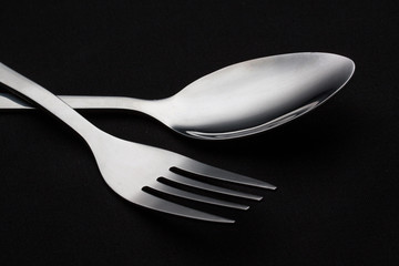 a silver fork with spoon isolated on black background