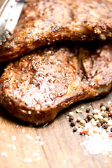 grilled steaks on an old wooden board pair