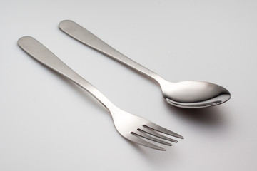 a silver fork with spoon isolated on gray background
