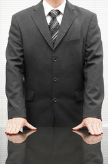 Closeup  of a well dressed businessman with hands on the desk at