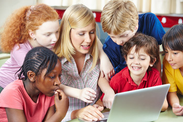 Schüler und Lehrer mit Computer im Internet