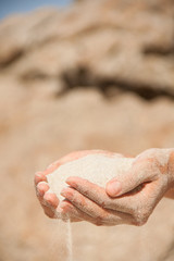 sand flows through the female hands