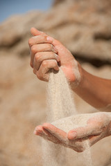 sand flows through the female hands