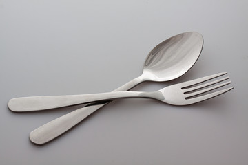 a silver fork with spoon isolated on gray background