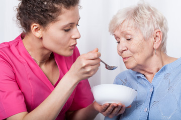 Nurse feeding an older lady