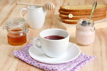 Breakfast with tea, honey, blueberries and yogurt