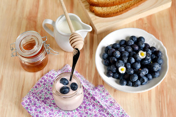 Breakfast with blueberries, honey and yogurt
