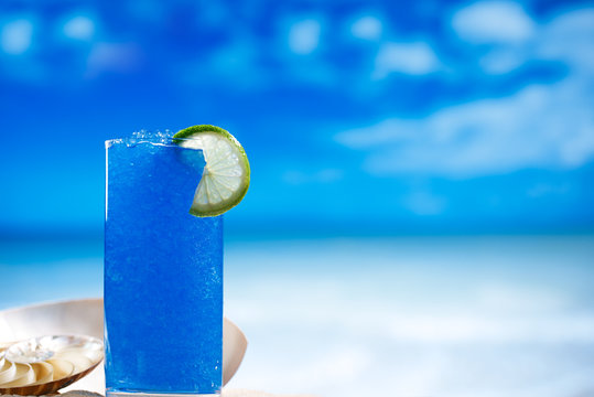 Blue Slush Ice In Glass  On Sea Beach Background