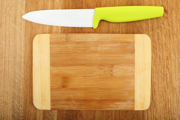 Kitchen knife and cutting board on wooden table