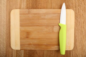 Kitchen knife and cutting board on wooden table