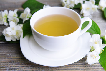 Fototapeta na wymiar Filiżanka herbaty z jaśminem w tabeli bliska