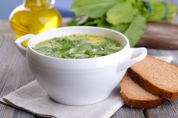 Delicious green soup with sorrel on table close-up