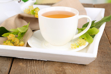 Tasty herbal tea with linden flowers on wooden table