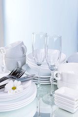 Set of white dishes on table on light background