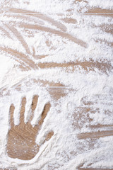 Fototapeta premium female palm print on flour scattered. vertical background