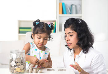 indian mother teaching daughter on financial planning indoor