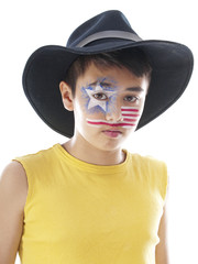 cute boy with fancy  stars and stripes face paint wears a leather cowboy hat