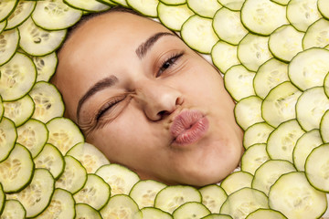 Portrait of beautiful woman with facial mask of cucumber slices