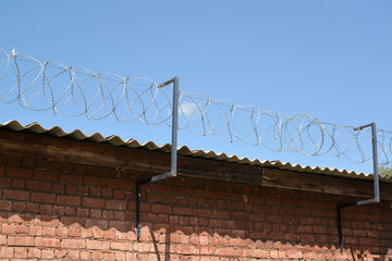 Fototapeta premium The barbed wire is tense over a brick wall