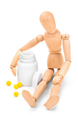 Wooden man embracing medical container with vitamins