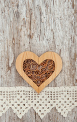 Wooden heart and lace fabric on the old wood