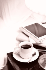 a cup of coffee on the bedside table and lamp