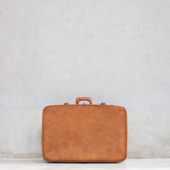 vintage suitcase and blank concrete background