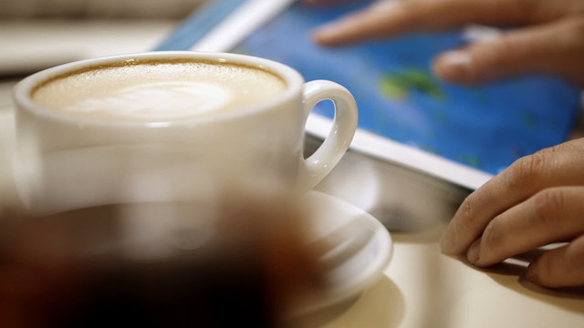Woman using touch pad during coffee break