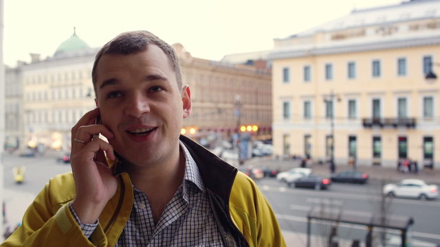 Young excited man talking on the phone outdoor