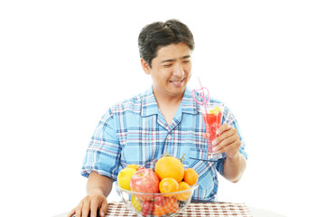 Obraz premium ジュースを飲む笑顔の男性