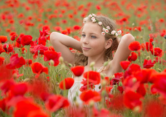 Obraz na płótnie Canvas Beautiful young kid in red poppy field