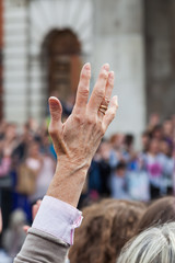 Frau hebt die Hand in der Menge