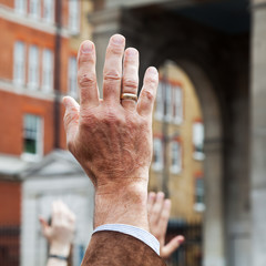 Mann hebt in der Menge die Hand hoch