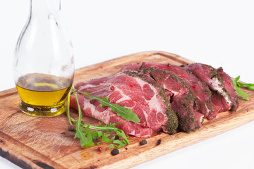 Raw marinated meat with spices on wooden board