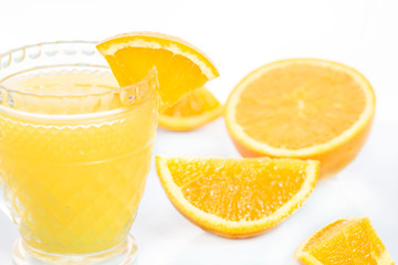Glass of freshly pressed orange juice with sliced orange half on