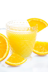 Glass of freshly pressed orange juice with sliced orange half on