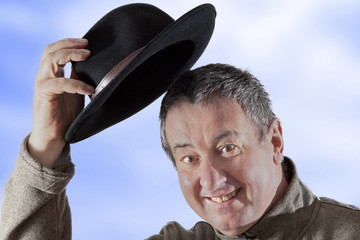 Man lifts hat in greeting