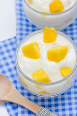 Yoghurt with mango  in a glass jars on white background