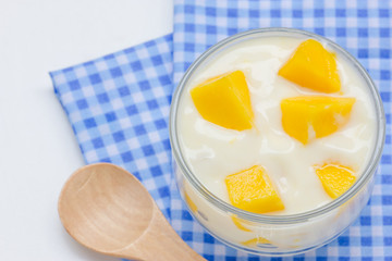 Yoghurt with mango  in a glass jars on white background